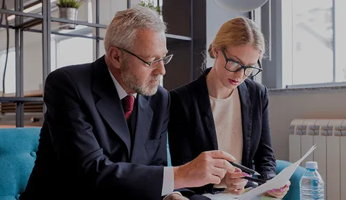 Prawnik analizujący z klientem dokumenty konieczne do uzyskania odszkodowania.